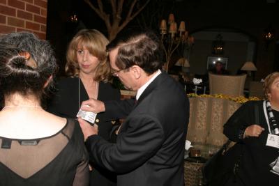 Larry Davis assists wife,  Nancy Kauderer with her nametag.